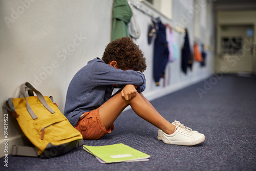 Obraz na płótnie Depressed boy sitting on corridor floor at school