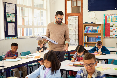 Quadro su tela Teacher walking among school desks while dictating exercise