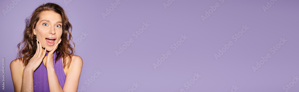 A stylish young woman in a purple dress making a surprised face against a vibrant orange background. A stylish young woman in a purple dress making a surprised face against a vibrant orange background.