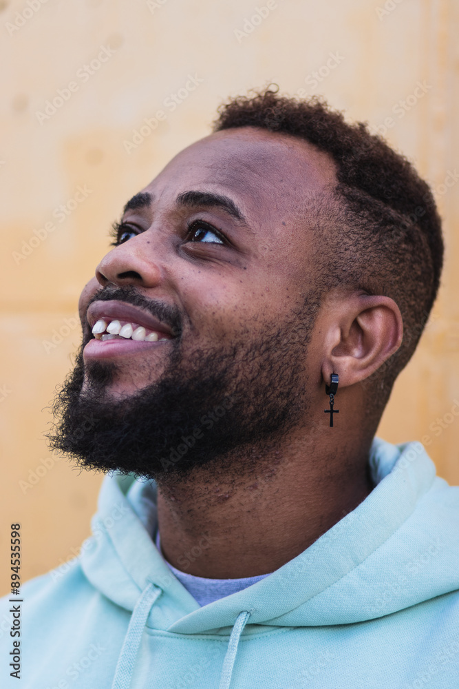 Fototapeta premium Portrait of cheerful bearded black man over yellow wall