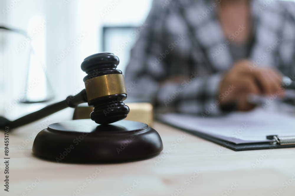 In a lawyer's office, a businessman consults an attorney for legal advice on a contract. The gavel symbolizes authority and justice. The lawyer explains the legislation and provides guidance on the ag In a lawyer's office, a businessman consults an attorney for legal advice on a contract. The gavel symbolizes authority and justice. The lawyer explains the legislation and provides guidance on the ag
