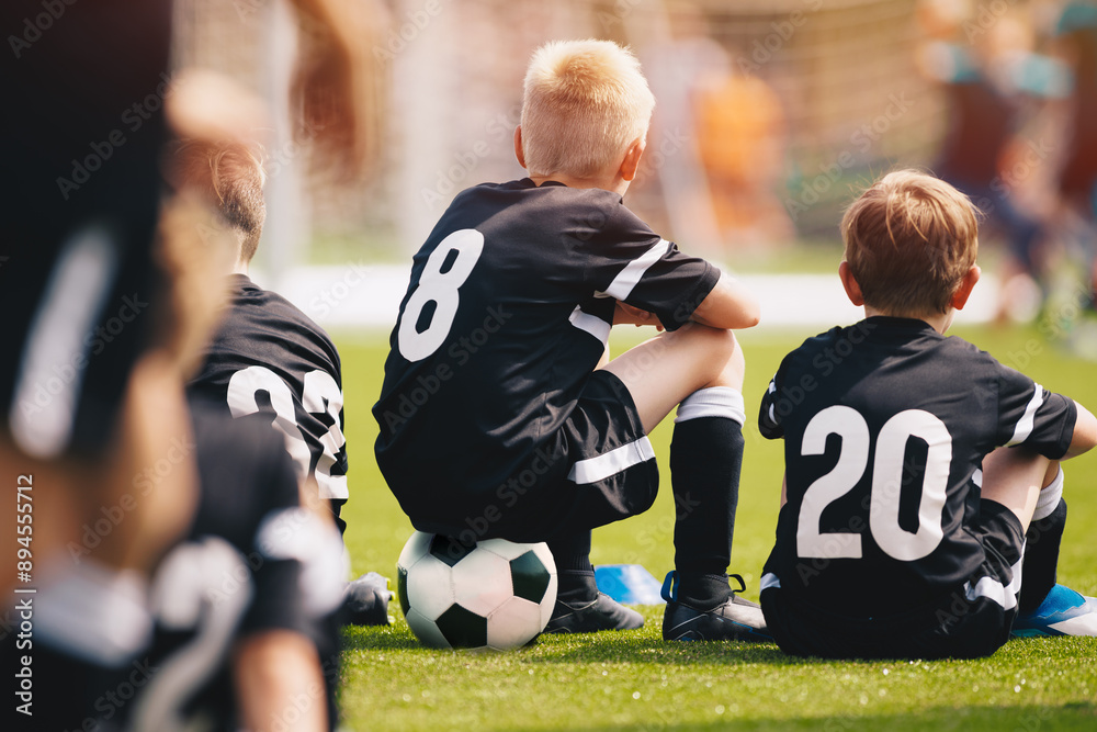 Youth soccer football team. The soccer team is practicing penalty kicks. Group photo. Soccer players sitting together at training. Teammates at youth soccer league game Youth soccer football team. The soccer team is practicing penalty kicks. Group photo. Soccer players sitting together at training. Teammates at youth soccer league game