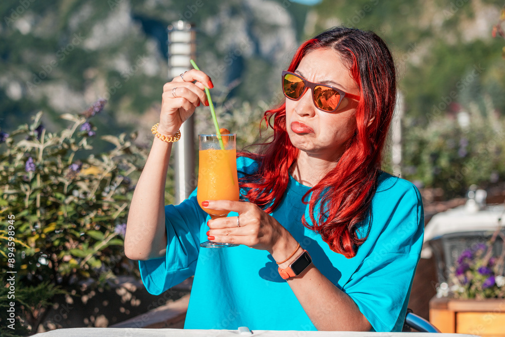 A woman with a disgusted expression, reacting to a spoiled orange juice, highlighting the unpleasant taste and smell of the beverage.