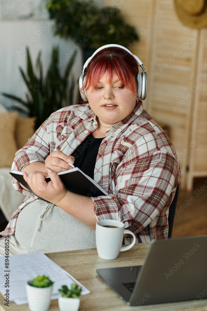 A woman with red hair sits at a desk, listening to music while writing in a notebook. A woman with red hair sits at a desk, listening to music while writing in a notebook.