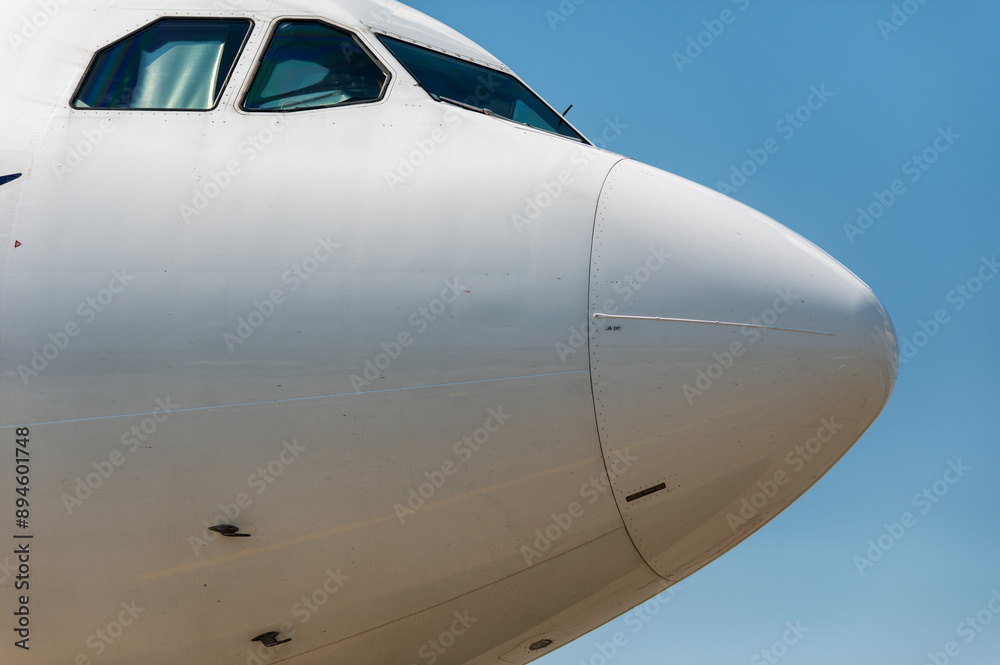 A close-up view of the cabin of a wide-body passenger jet in sunny weather. The cabin windows are covered with sun protection from the inside. A close-up view of the cabin of a wide-body passenger jet in sunny weather. The cabin windows are covered with sun protection from the inside.