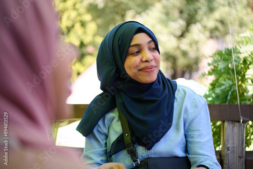 Middle Eastern Muslim Woman Enjoying Coffee and Conversation with Friend in Nature photo