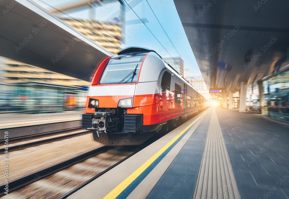 Fototapeta premium High-speed passenger train moving at railway station at sunset