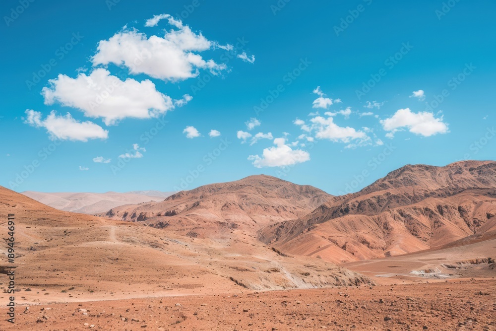 Vast and endless desert mountains under a blue sky with white clouds Vast and endless desert mountains under a blue sky with white clouds