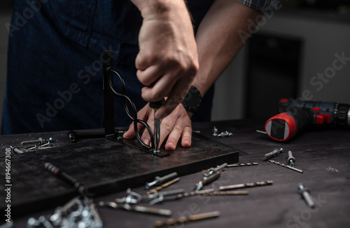 Man Makes Shelf From Board And Bracket For Attaching Hand In Close-Up