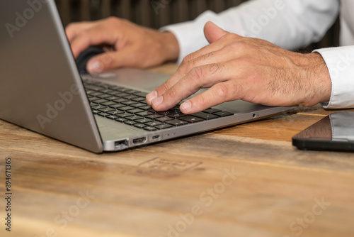 mains d'un homme travaillant sur un PC portable travail de bureau, envoi de mail photo