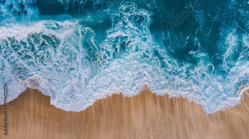 Create an aerial view of a sandy beach and the ocean with waves. Highlight the textures of the sand, the patterns of the waves, and the contrast between the beach and the ocean. Showcase the natural b photo