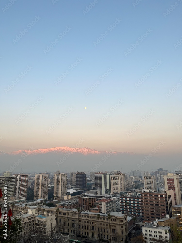 Obraz premium Skyline of Santiago, Chile, with the Andes Mountains in the background during a hazy winter sunset.