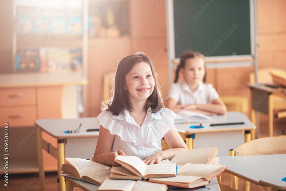 Cute girls are sitting in a classroom at a desk with notebooks and textbooks. The children listen carefully to the lesson. Back to school. School supplies. Student at a lesson, class during a lesson.
Cute girls are sitting in a classroom at a desk with notebooks and textbooks. The children listen carefully to the lesson. Back to school. School supplies. Student at a lesson, class during a lesson.