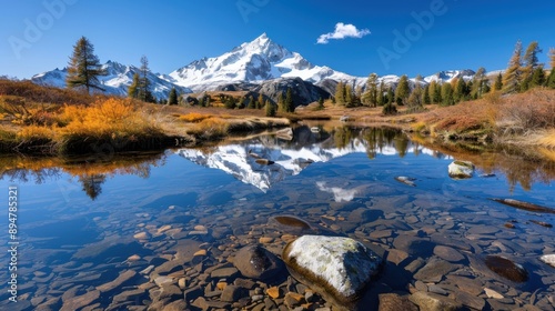 A stunning scene of a tranquil lake reflecting a majestic snow-capped mountain, surrounded by autumn foliage, showcasing the serene beauty of nature in crisp autumn air.