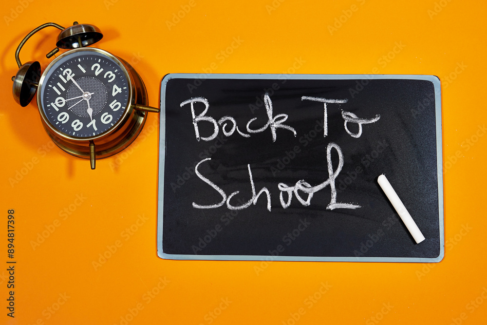 back to school text chalkboard with alarm clock. Education in high school university college concept back to school text chalkboard with alarm clock. Education in high school university college concept