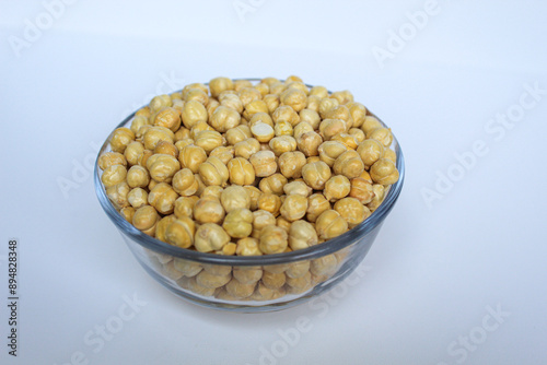 Chickpeas in glass transparent bowl, isolated on white background photo