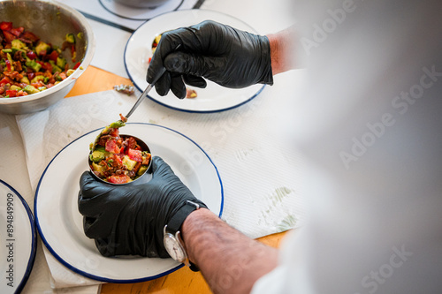 Fototapeta Naklejka Na Ścianę i Meble -  Réalisation d'un plat gastronomique avec vue sur les mains du cuisinier et les gants