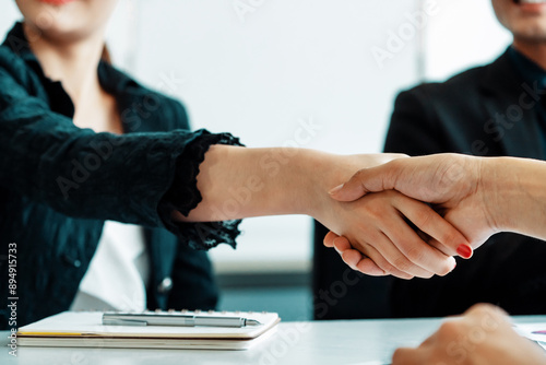 Business people agreement concept. Businessman and Asian businesswoman do handshake in the office. uds