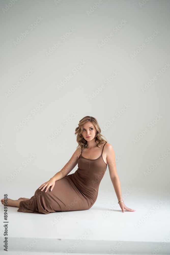 Obraz premium Vogue style woman in long brown slim dress 