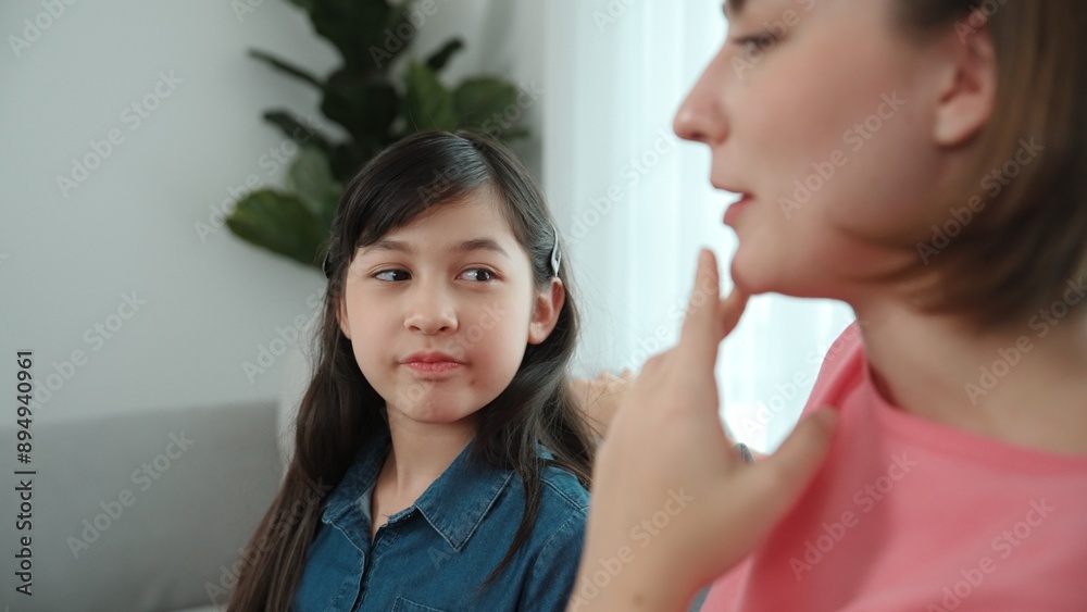 Happy mother sharing experience with daughter while sitting in living room. Caucasian mom and happy child talking and spend time together. Attractive girl listen parent story while smiling. Pedagogy. Happy mother sharing experience with daughter while sitting in living room. Caucasian mom and happy child talking and spend time together. Attractive girl listen parent story while smiling. Pedagogy.