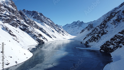 Drone view of Laguna del Inca in winter, located in the Andes Mountains of Chile, showcasing the frozen lake and surrounding snowy peaks