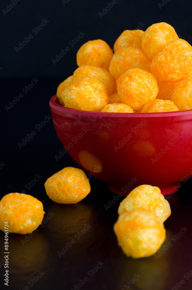 Closeup Vertical Image of Cheese Puffs in Red Bowl Closeup Vertical Image of Cheese Puffs in Red Bowl