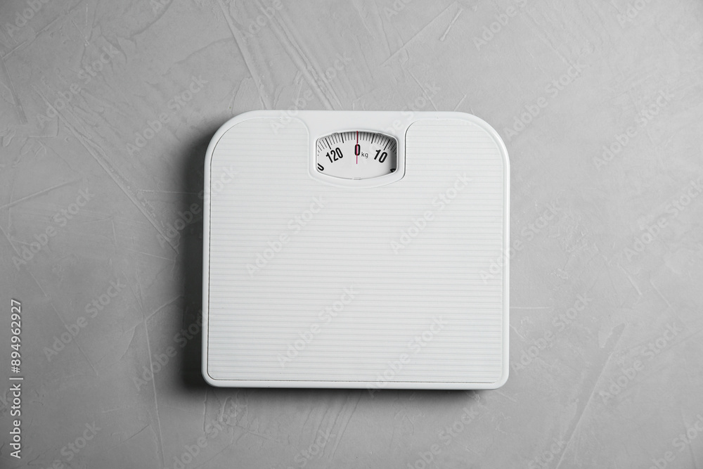 One bathroom scale on grey textured background, top view One bathroom scale on grey textured background, top view
