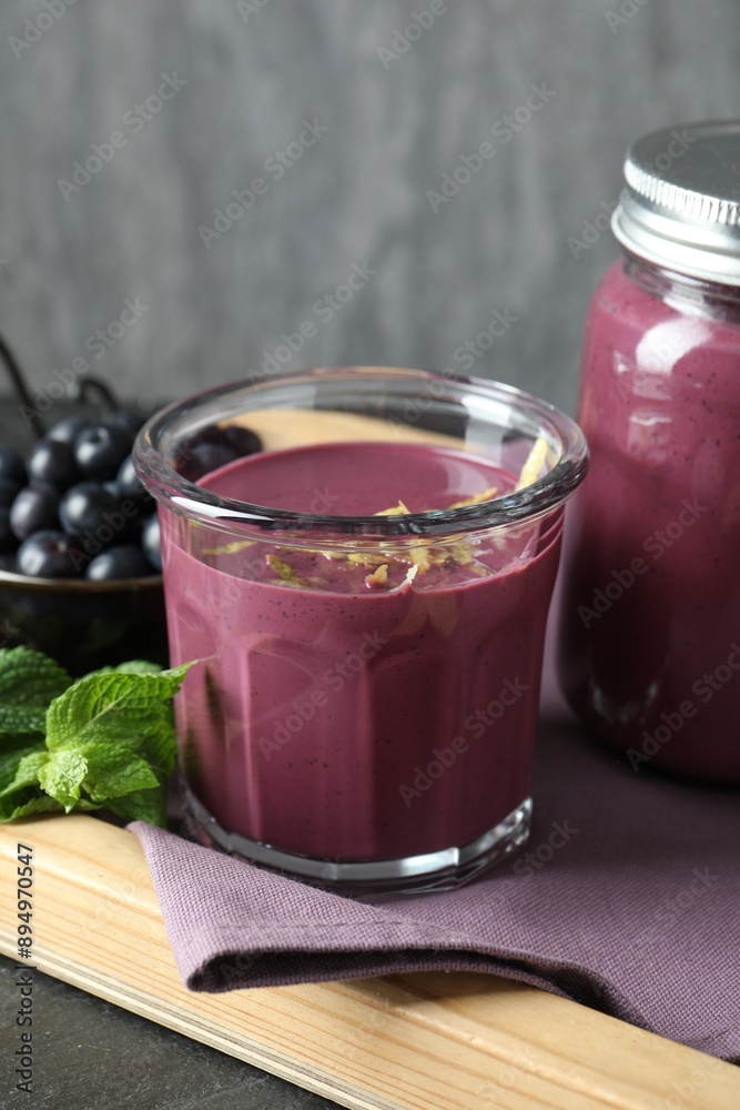 Tasty fresh acai juice with mint and berries on grey table Tasty fresh acai juice with mint and berries on grey table