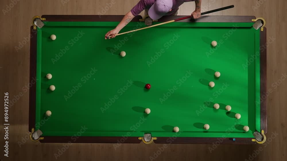 Top view full shot of russian billiard table with white balls scattered around, person polishing the billiard cue with chalk.
