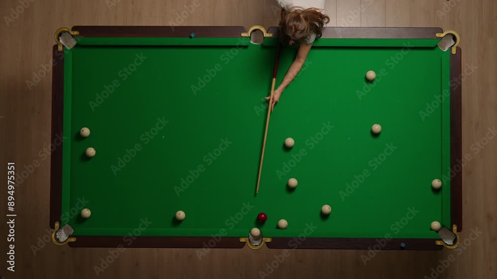 Top view shot of russian billiard green cloth table with red and white balls, woman hitting the balls with cue.