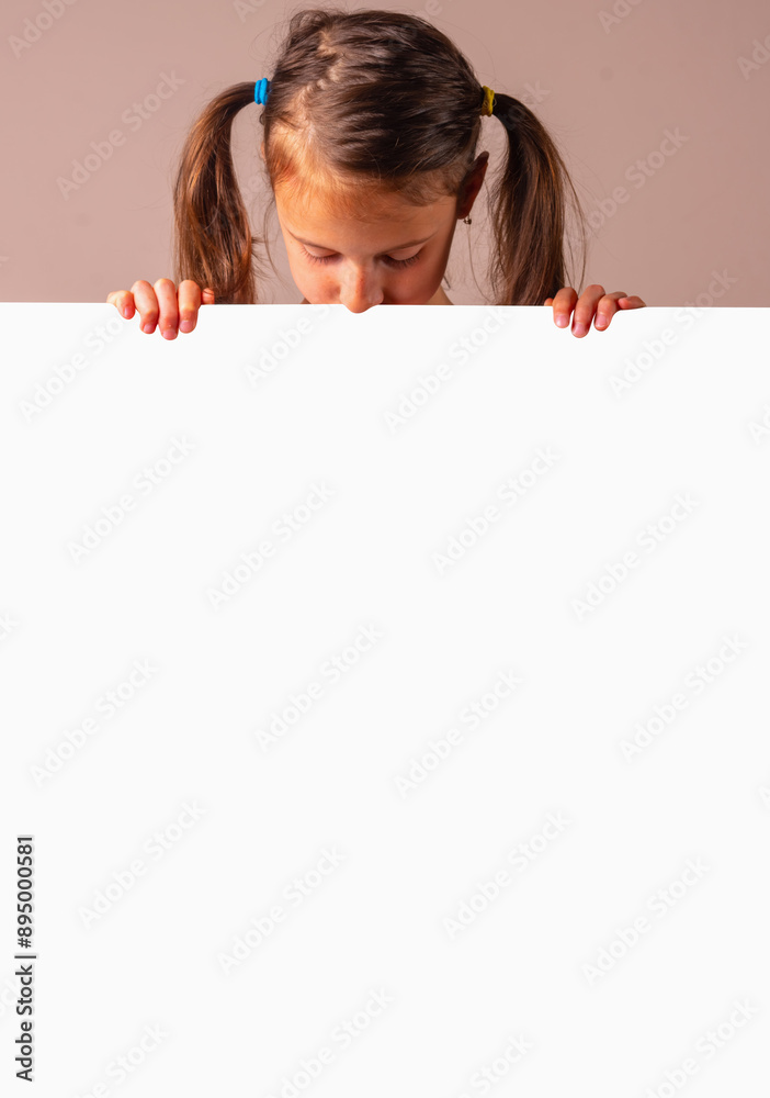 Cheerful attractive young girl behind white blank banner or empty copy space advertisement board on brown background, Copy space for text or design. Vertical image. Cheerful attractive young girl behind white blank banner or empty copy space advertisement board on brown background, Copy space for text or design. Vertical image.
