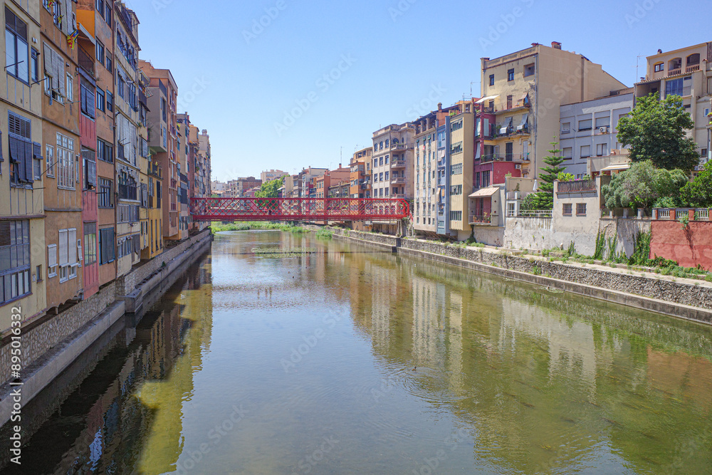 Naklejka premium Girona, Spain - 23 July, 2024: Colored houses on River Onyar, Girona, Catalonia