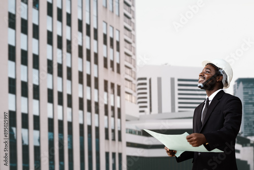 Foto African architect engineer wearing a white helmet stands at a modern building in the background