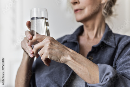 Senior woman in 60s drinking water photo