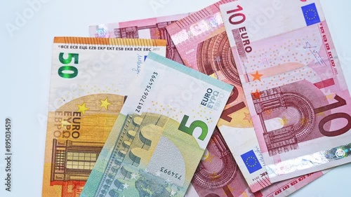 Falling euros banknotes and pile of euro currency banknotes are spinning on table