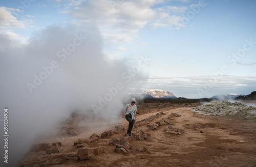 female tourist walk on orange gravel at Myvatn Geothermal area photo