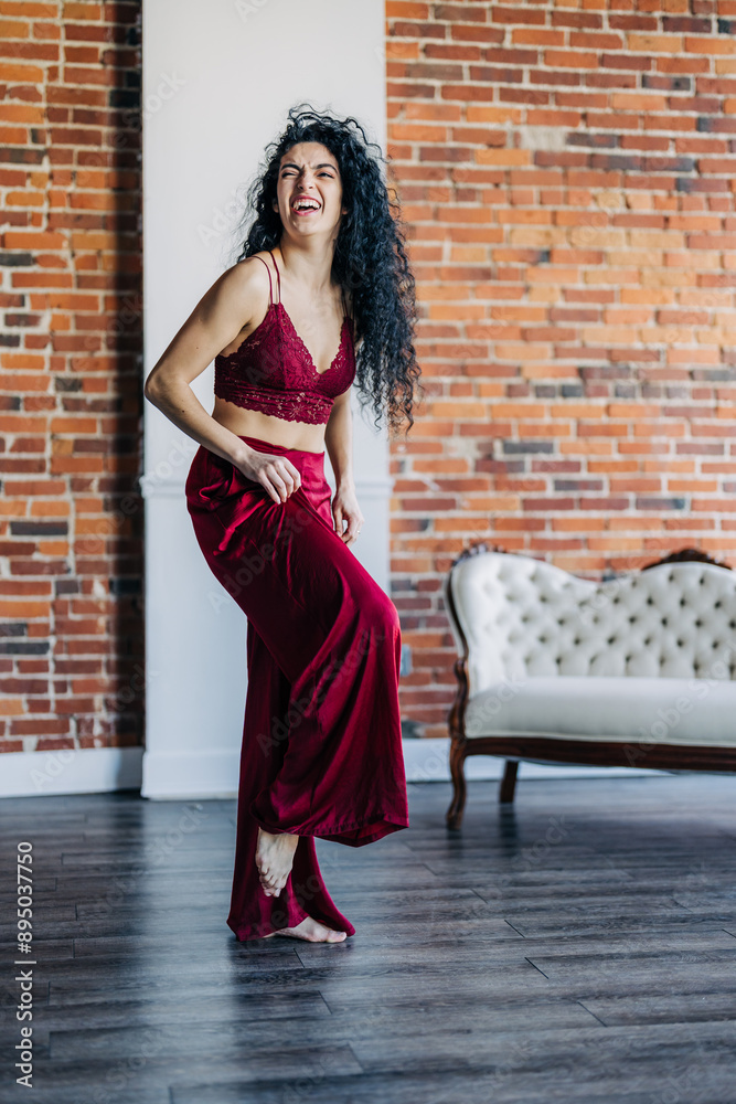 Woman laughing joyfully while dancing indoors Woman laughing joyfully while dancing indoors