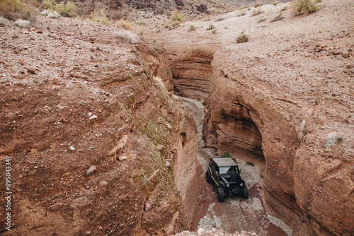 Off-road vehicle navigating a narrow canyon.