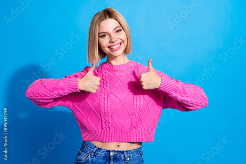 Portrait of nice young woman show thumb up wear pink sweater isolated on blue color background