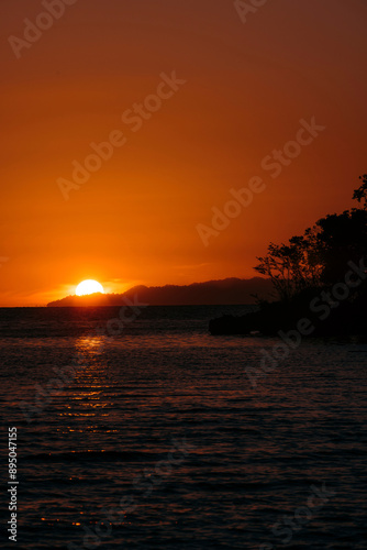 Dramatic glowing sunset and red sky viewed from a resort on Bolilanga Island in the Tongean Islands of Indonesia; Bolilanga, Togean Islands, North Sulawesi, Indonesia photo