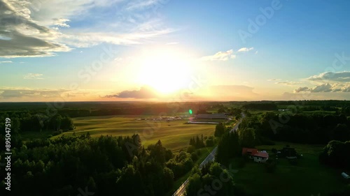 Landscape pan of beautiful early morning sunrise on horizon with rays bursting through clouds in sky scenery nature outdoors countryside farm acreage rural town