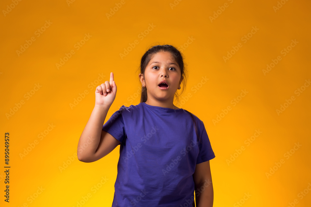 Obraz na plátně Surprised girl pointing finger up with successful idea