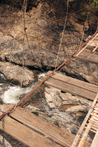 Rickety suspension bridge and waterfall below on the island of Don Khon, Laos; Don Khon, Champasak Province, Laos photo