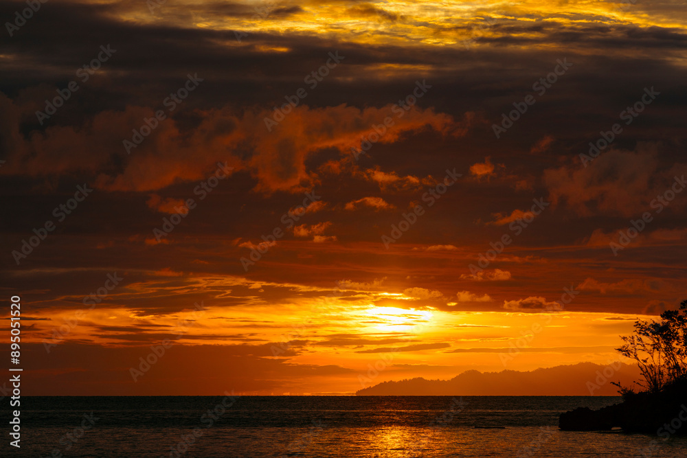 Dramatic skies at sunset over Bolilanga Island in the Tongian Islands of Indonesia; Bolilanga, Togian Islands, North Sulawesi, Indonesia Dramatic skies at sunset over Bolilanga Island in the Tongian Islands of Indonesia; Bolilanga, Togian Islands, North Sulawesi, Indonesia