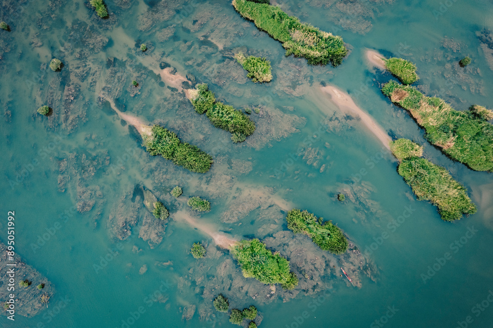 Aerial view of directly above a number of small islands with green vegetation in aquamarine coloured water in the Four thousand islands area (Si Phan Don) in southern Laos; Champasak Province, Laos Aerial view of directly above a number of small islands with green vegetation in aquamarine coloured water in the Four thousand islands area (Si Phan Don) in southern Laos; Champasak Province, Laos
