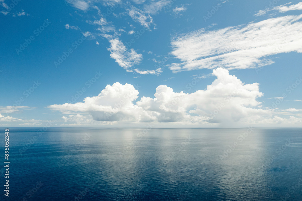 custom made wallpaper toronto digitalBright clouds in a blue sky reflecting a mirror image into the tranquil blue water of the Molucca Sea at Kepulauan Togean National Park; Wakai, Central Sulawesi, Indonesia