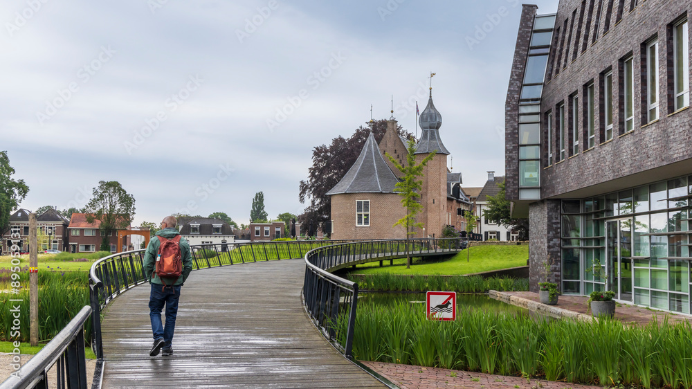 Obraz premium Toerist crossing the bridge towards the castle in Coevorden in Drenthe The Netherlands