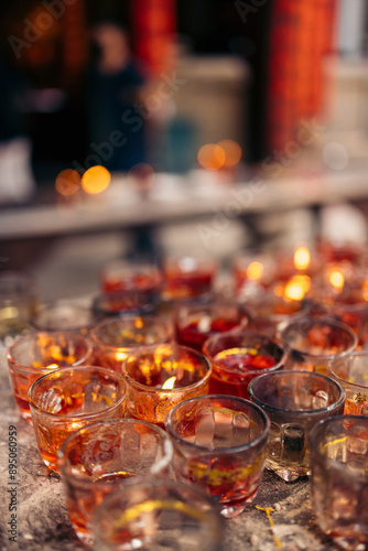 Illuminated tealight candles in decorative glass jars in the buddhist temple Ba Thien Hau Temple in Ho Chi Minh City; Ho Chi Minh City, Vietnam