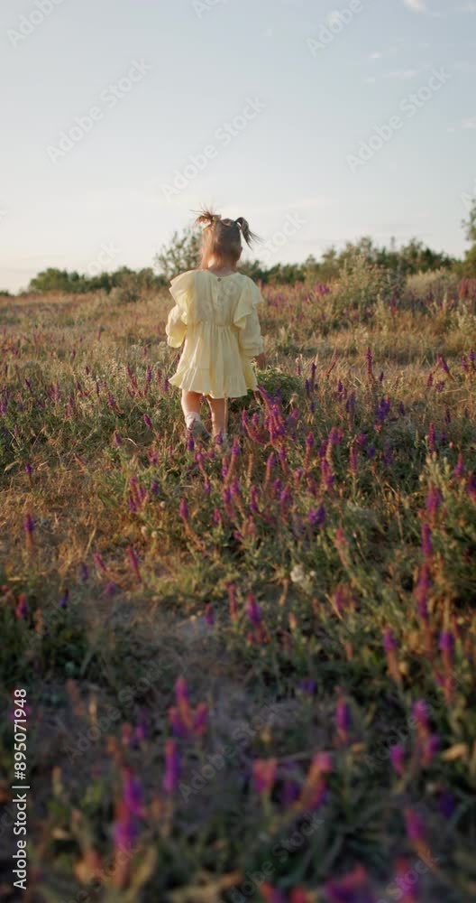 Little cute child girl running outdoor with wild flowers and evening sunlight Little cute child girl running outdoor with wild flowers and evening sunlight