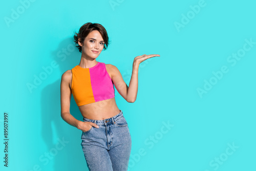 Photo of sweet shiny woman wear pink orange top showing arm empty space isolated teal color background